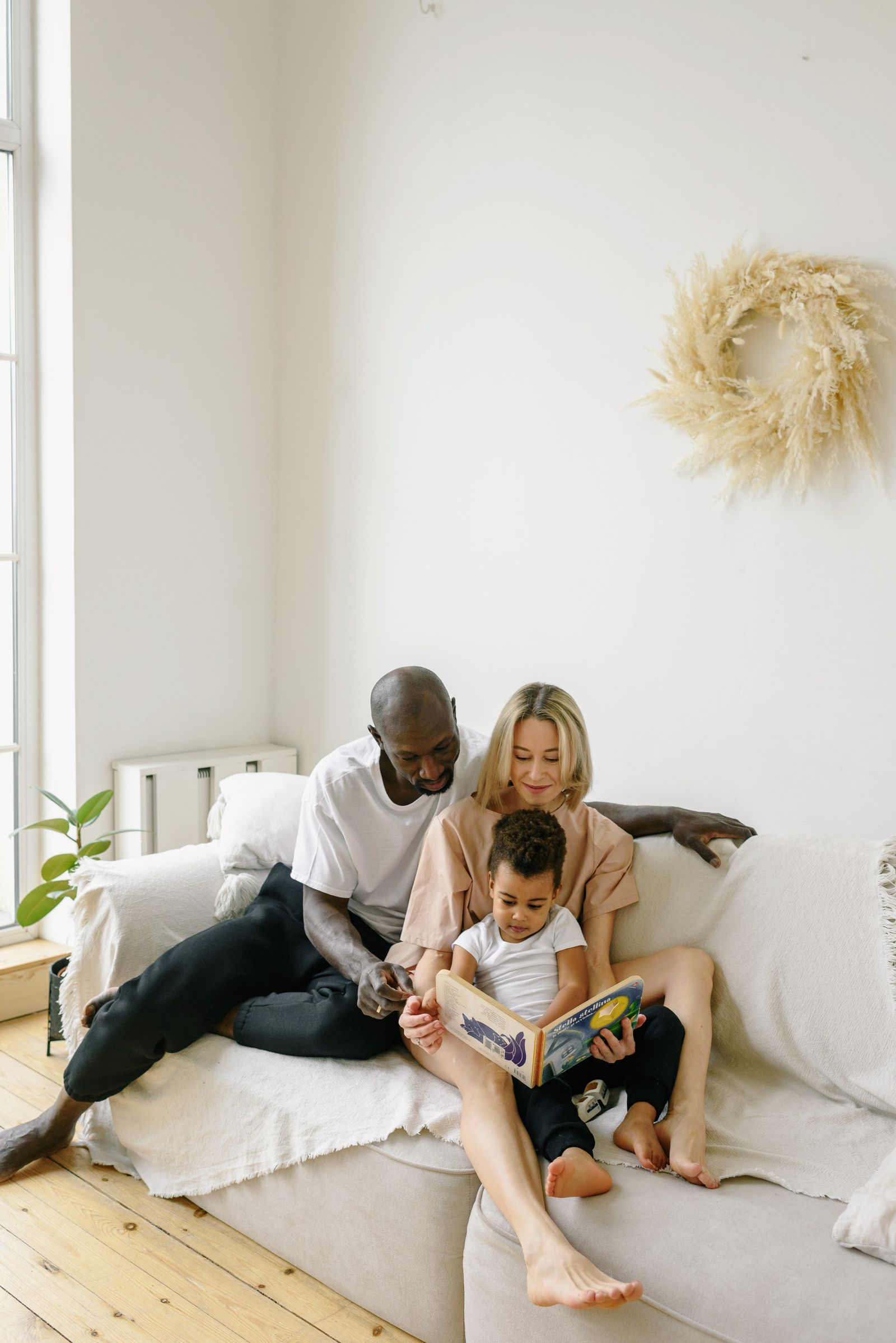 A parent and child reading together in a comfortable home setting